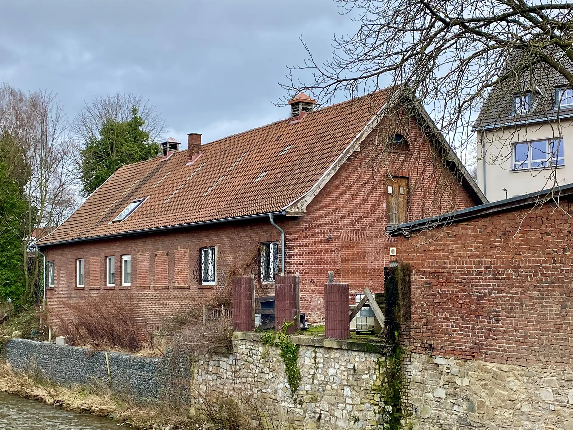 Älteres Haus von Außen neben einen Fluss