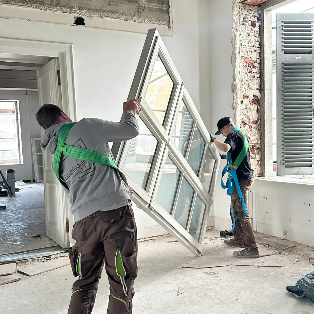 Arbeiter setzen neue Fenster ein