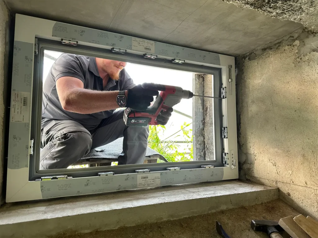 Flutschutzfenster wird von Arbeiter in Wand eingesetzt