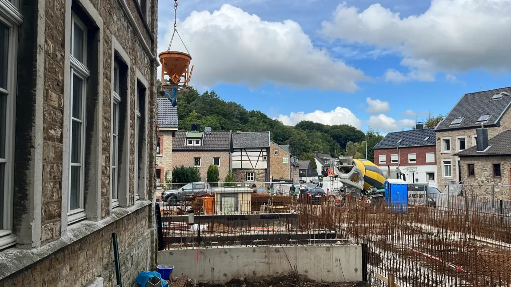 Baustelle an der Straßenseite mit Betonmischer und Altbau der Kita Vicht in Stolberg.