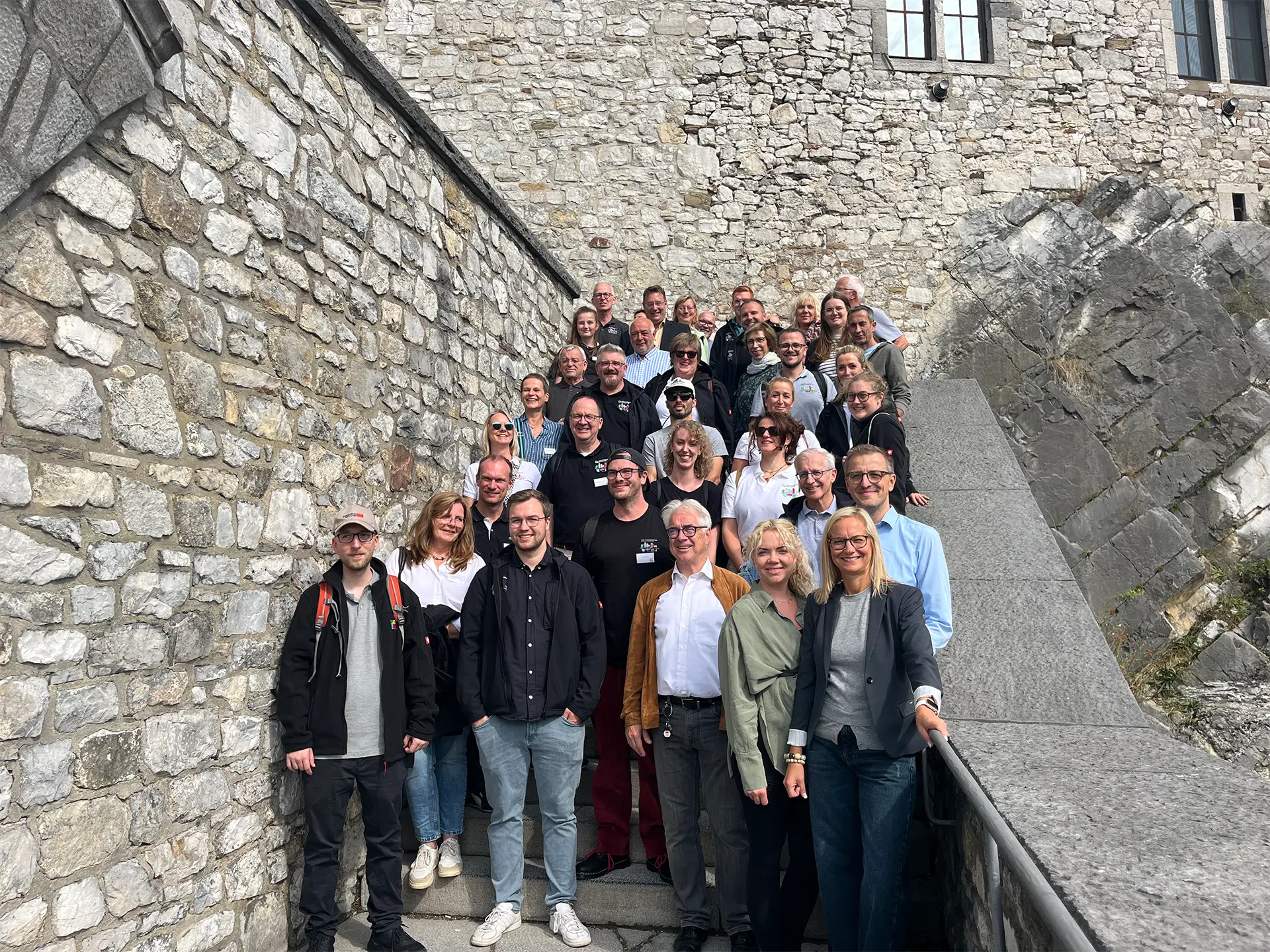 Gruppenfoto beim Austausch des Wiederaufbau Stolberg Teams vor historischer Kulisse