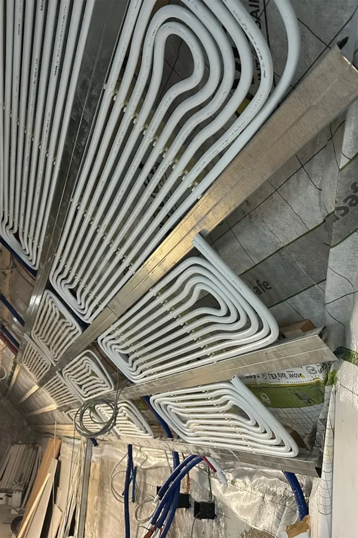 Montage von Heiz- und Kühldecken im Ratssaal: In Metallkassetten verlegte Rohrleitungen für ein strahlungsbasiertes Heiz- und Kühlsystem vor der finalen Deckenverkleidung.