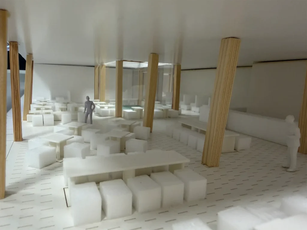 Innenansicht des Architekturmodells für den Rathausneubau Stolberg mit offenen Arbeitsbereichen, Sitzgruppen und markanten Holzstützen.