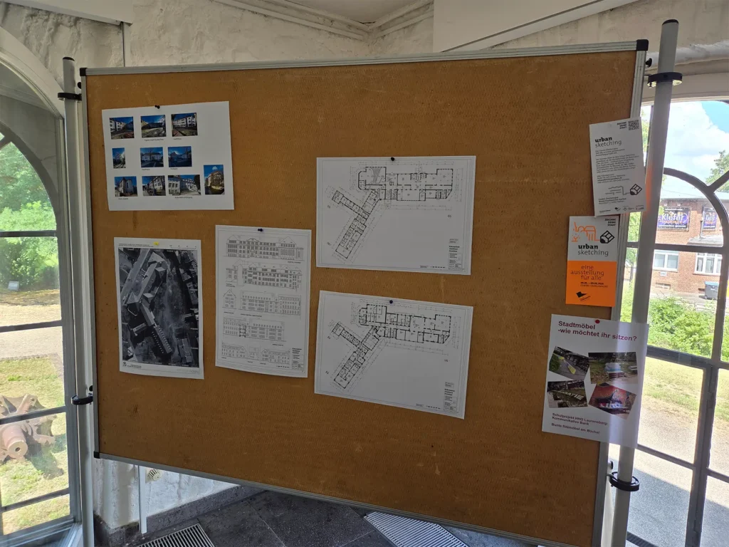 Pinnwand mit Entwürfen, Grundrissen, Ansichten und Fotodokumentationen eines städtebaulichen Projekts sowie Informationen zu einer Ausstellung und Beteiligungsformaten.