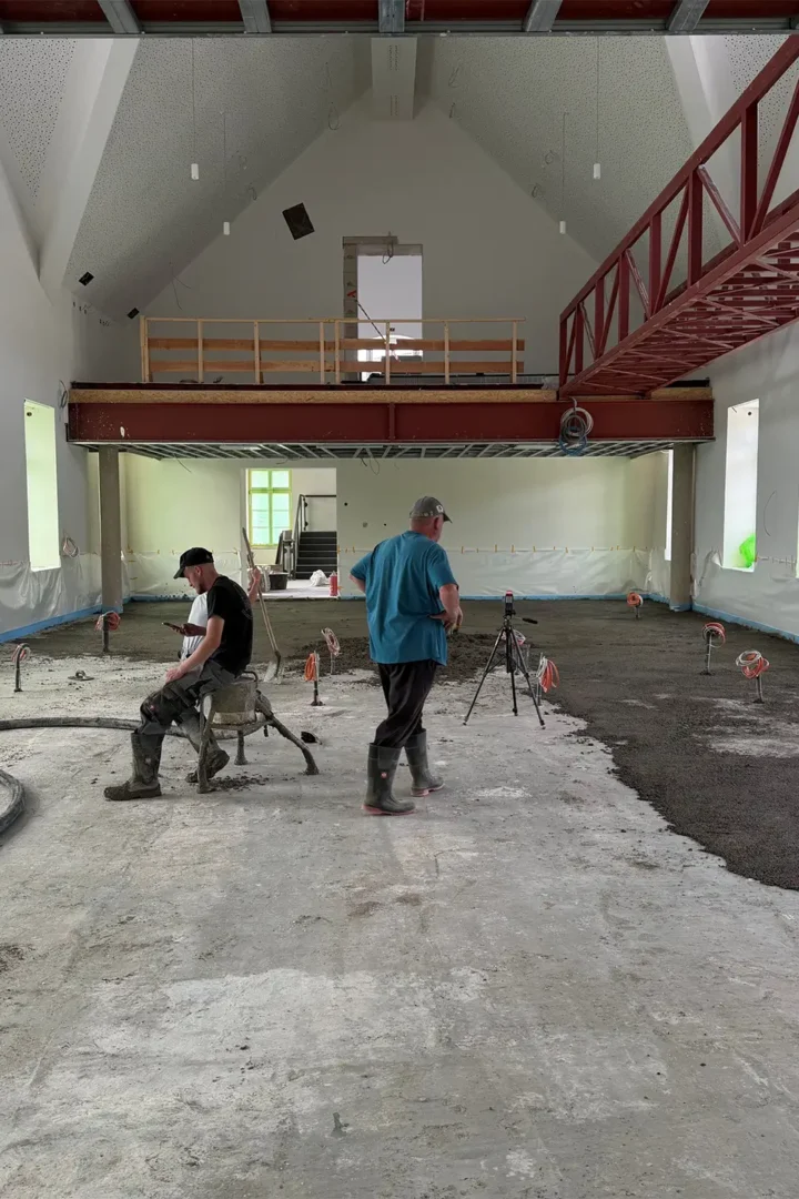 Bauarbeiten im historischen Rathaus der Kupferstadt Stolberg: Fachkräfte bringen den neuen Estrich im großen Saal auf und bereiten den Boden für den weiteren Innenausbau vor.