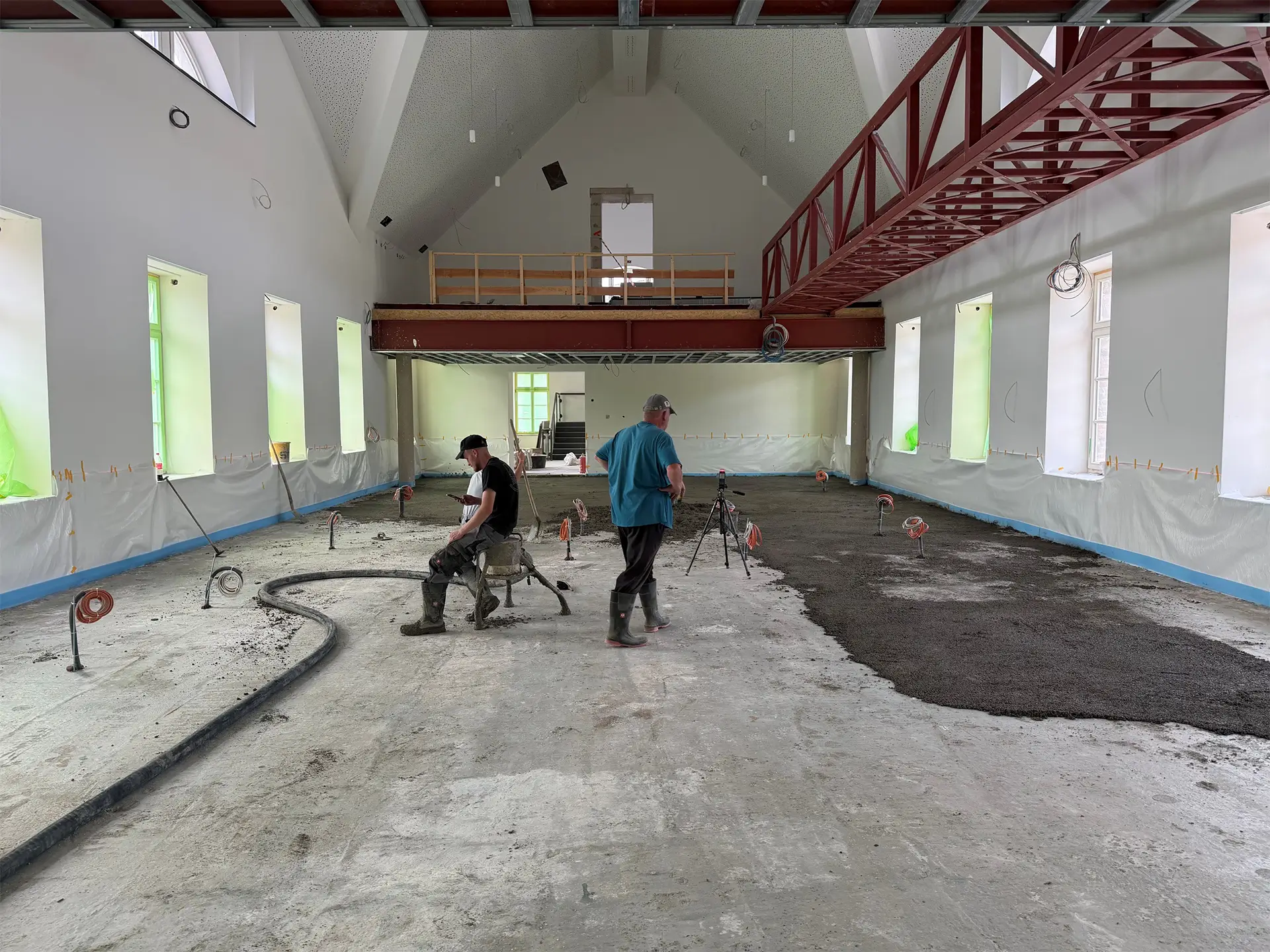 Bauarbeiten im historischen Rathaus der Kupferstadt Stolberg: Fachkräfte bringen den neuen Estrich im großen Saal auf und bereiten den Boden für den weiteren Innenausbau vor.