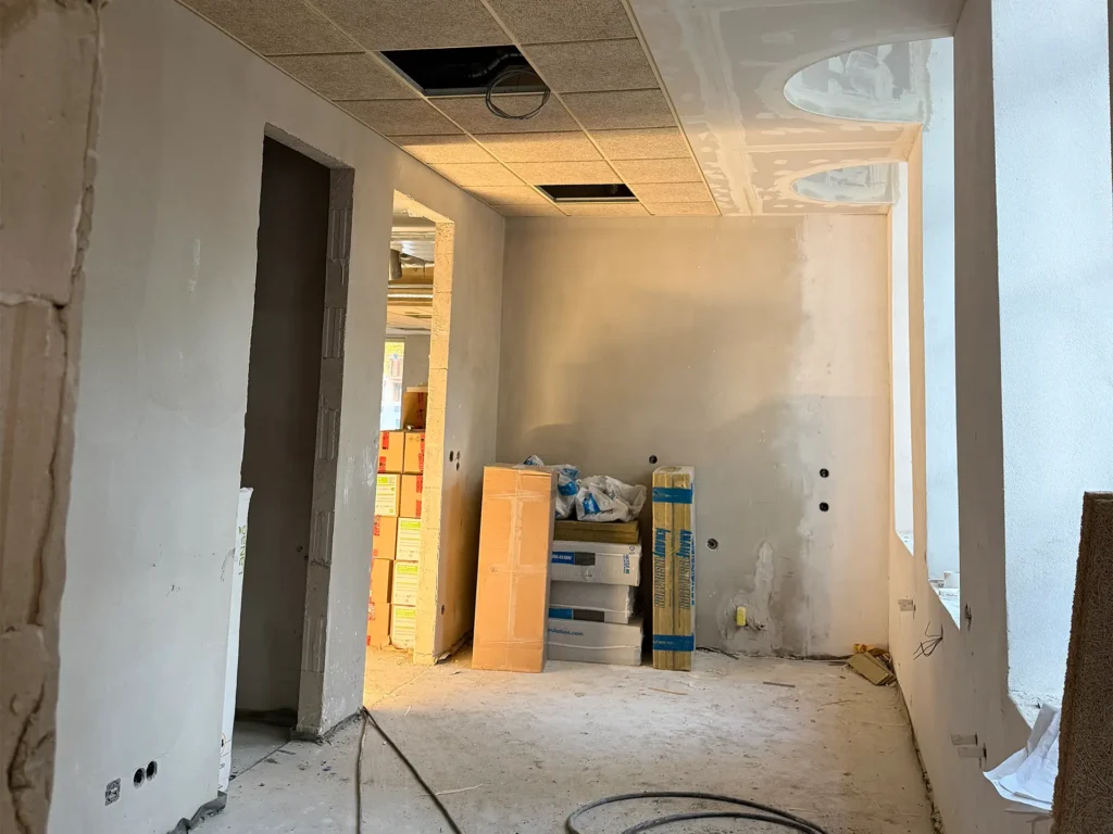 Flurbereich der Kita Vicht im Umbau mit neuen Wandflächen, Deckenkonstruktion und gelagerten Baumaterialien.