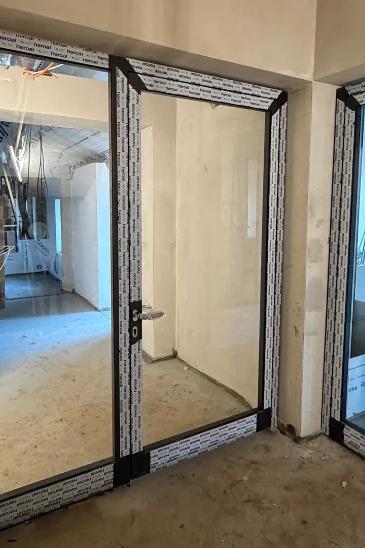 Neu eingebaute Glastüren mit dunklen Rahmen während der Sanierungsarbeiten in der Kita Vicht.